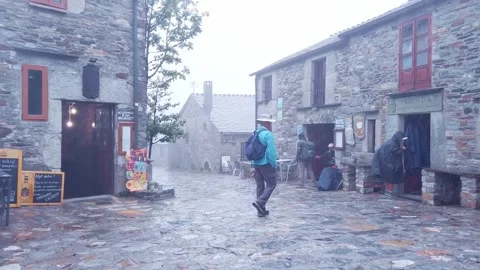 Pilgrim walking through the rain in the town of O Cebreiro. Video stock 256422109