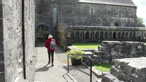 Pilgrim walking towards Abbey Stock Footage 230988433