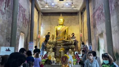 Pilgrims decorating buddha statue with gold petals. Video stock 205074134