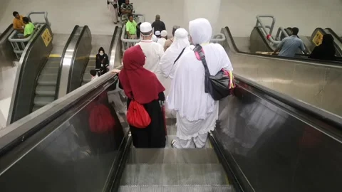 Pilgrims descend from Jamarat building using a group escalator. Stock Footage 130228403