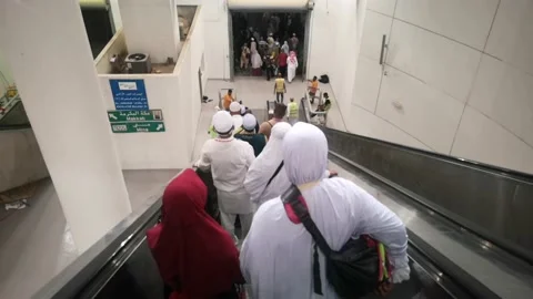 Pilgrims descend from Jamarat building using a group escalator. Stock Footage 130297253
