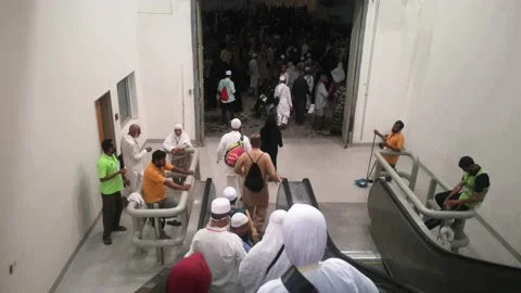 Pilgrims descend from Jamarat building using a group escalator. Stock Footage 130297276