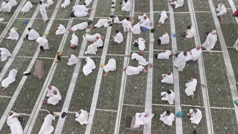 Pilgrims in 'ihram' clothes rest inside Al Haram Mosque in Makkah, Saudi Arabia Видео 274472612