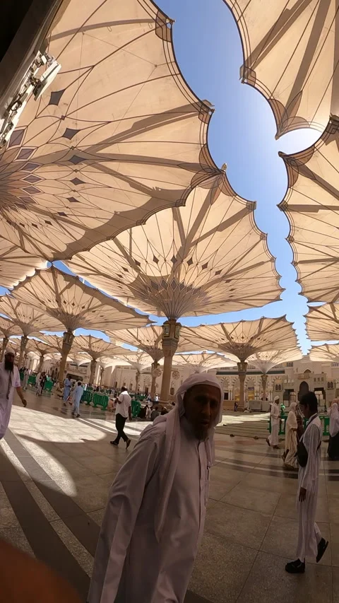 Pilgrims at Prophet Mosque Under Giant Umbrellas Stock Footage 332662248