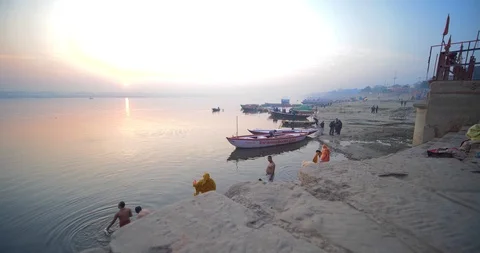 Pilgrims taking a holy dip at sunrise in sacred river Ganges, Varanasi, India Stock Footage 115288191