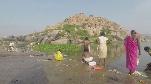 Pilgrims talk, pray, bathe and wash clothes by river. Stock Footage 83469375