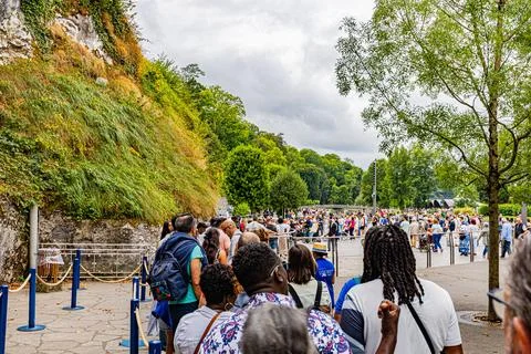Pilgrims Walking Under Tree Shaded Avenue in Lourdes Sanctuary Stock Photos