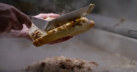 Piling chopped steak and onions into a long roll, creating a Philly cheesesteak Stock Footage