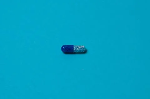 Pill on a blue background, isolate, with place for text. Fotos Stock
