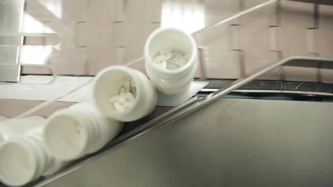Pill Bottle Capping Machine - Pill Bottles being Queued for Capping Stock Footage 71455441