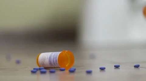 Pill Bottle Falls into Frame with Pills and Bottle on Floor Video stock 56597011