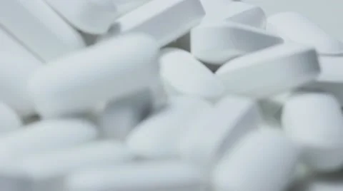 Pill bottle on its side with white tablet pills overflowing Stockbeeldmateriaal 68806399