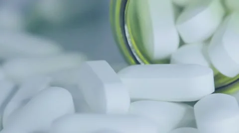 Pill bottle on its side with white tablet pills overflowing Stock Footage 68806471