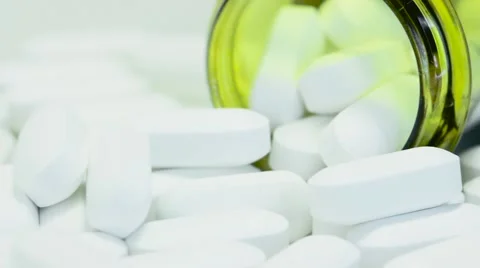 Pill bottle on its side with white tablet pills overflowing 스톡 동영상 68806477