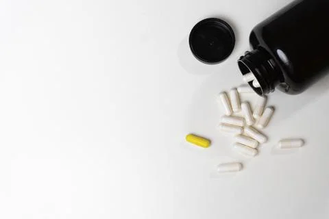 Pill bottle spilling pills on to table on a white background Stock Photos