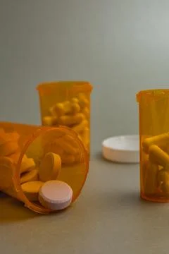 Pill bottles and tablets on a plain surface during indoor setting Stock Photos