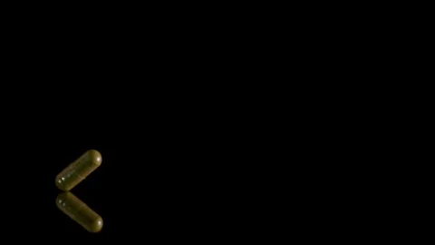 Pill capsule falling on the mirror table. Slowmotion shot, 180 fps Stock Footage 86283802