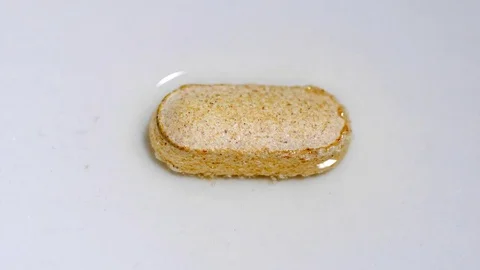Pill capsule, Timelapse Macro shot Dissolves In Water. White background close up Stock Footage 73454842