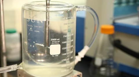 Pill dropped into a beaker of liquid in a science laboratory experiment Video stock 65887696