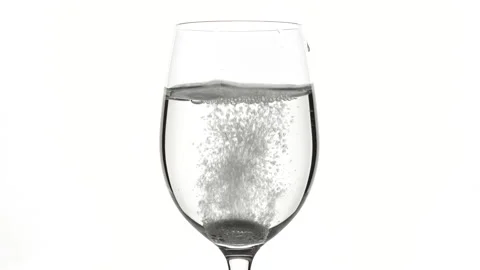 Pill of effervescent aspirin falling down in elegant glass with water Video stock 137217269
