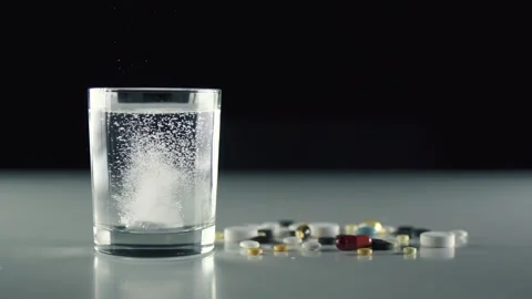 Pill falling down in glass with water and make acidity bubble. Stock-Footage 163230564