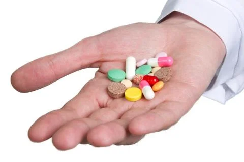 Pill in a hand isolated on white Stock Photos