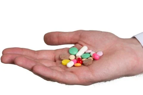 Pill in a hand  on white background Stock Photos