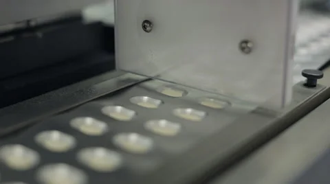 Pill Machine Dropping Pills into Blister Packaging Pockets Stock Footage 68642696