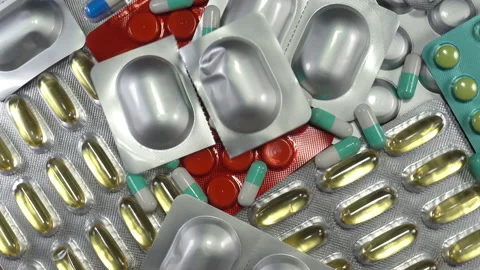 A pill in a package falls on a bunch of pills in 4K Stock Footage 159639635