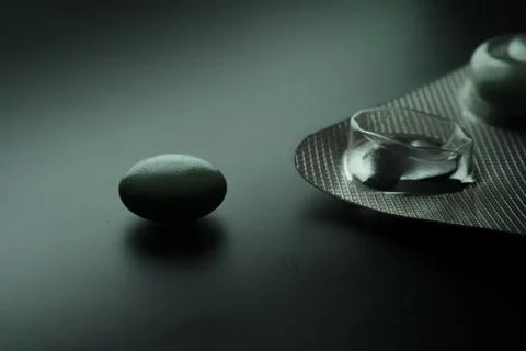 Pill remaining next to empty blister pack showcasing addiction Stock Photos