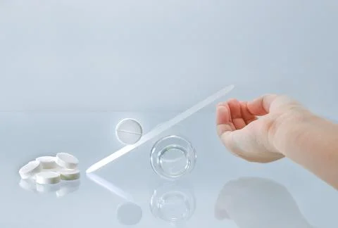 The pill rolls down the slide into the palm of your hand. Stock Photos