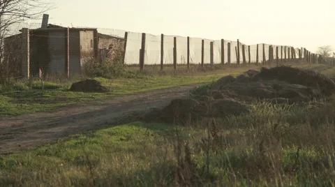 Pillars Hold Chain-Link Fence Beside Road at Which Pours Water From a Tank Stock Footage 62472595