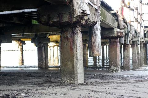 Pillars supporting the pier on the beach Stock Photos