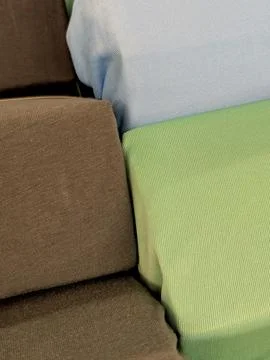 Pillows arranged in neutral interior space close-up brown light blue green .. Stock Photos