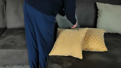 Pillows for the sofa.Woman laying out pillows on the sofa. Stock Footage 238758539