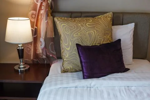 Pillows on white bed sheet bedding and lamp on bed side table. Twin beds room Stock Photos