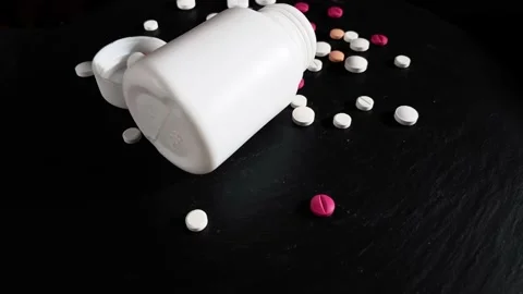 Pills and bottle rotating on black background. Video stock 232870093