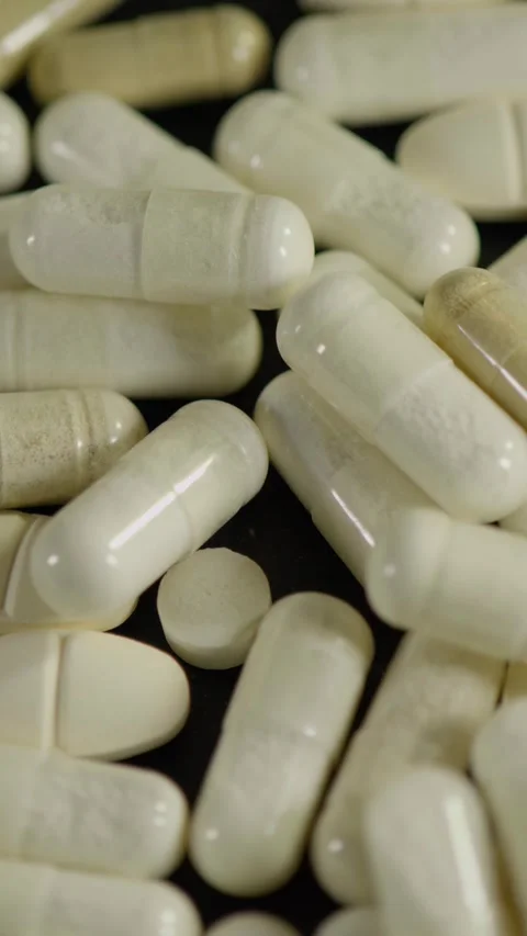 Pills and Capsules Falling Macro Stock Footage 345426474