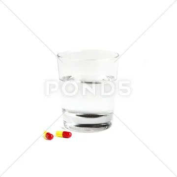 Pills and a glass of water Stock Photos