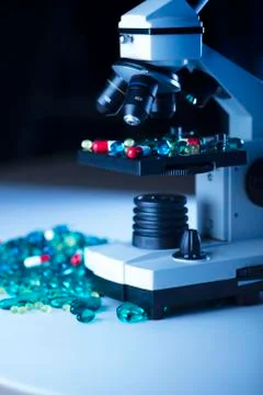 Pills and microscope Stock Photos