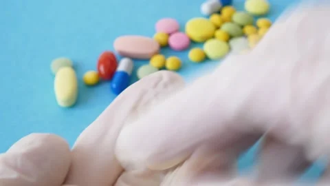 Pills and tablets on blue background. checking ingredients and effectiveness  Video stock 169526196