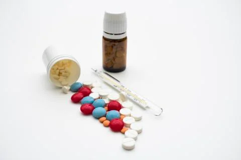 Pills and thermometer Stock Photos