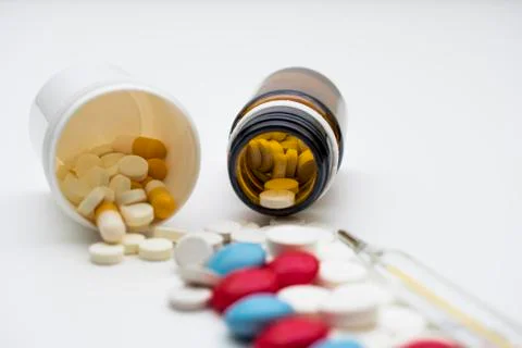 Pills and thermometer Stock Photos