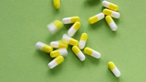 The pills are scattered on the table. Tablets on the green background. Medicinal Stock Footage 159830106