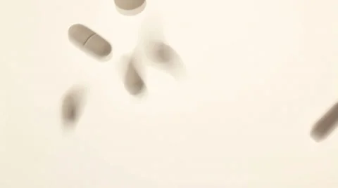 Pills being spilled onto a white surface Stock Footage 32243919