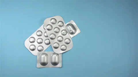 Pills in blisters falling in slow motion onto a pile Stock Footage 150728346