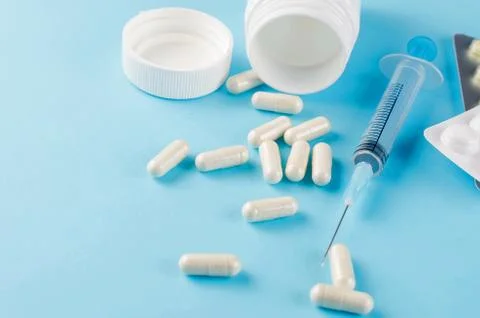Pills, blisters, syringe on a blue background Fotos Stock