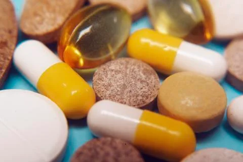 Pills on a blue background. Assorted pharmaceutical medicine pills, tablets a Stock Photos