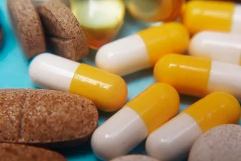 Pills on a blue background. Assorted pharmaceutical medicine pills, tablets a Stock Photos