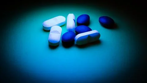 Pills on a blue background. Select focus. Toned. Stock Photos